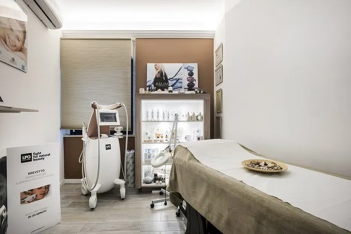 La cabina con il macchinario LPG, il lettino rivestito in tessuto sabbia e la vetrina dei prodotti
